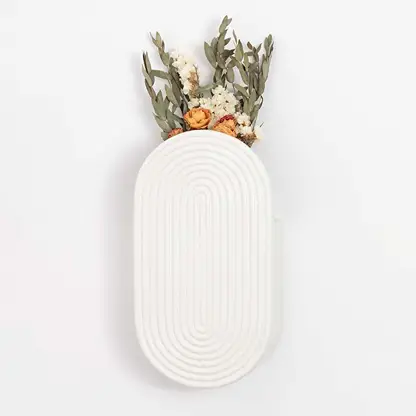 White ceramic wall vase with textured oval design shown against a clean background for modern home decor styling.