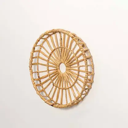 Side view of handcrafted natural rattan open center web wall basket wheel panel for modern bohemian home wall decor styling.