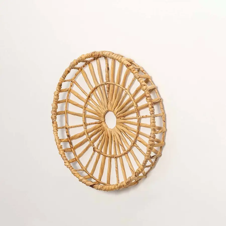 Side view of handcrafted natural rattan open center web wall basket wheel panel for modern bohemian home wall decor styling.
