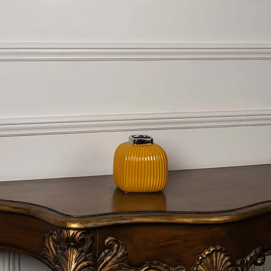 Yellow ribbed ceramic mini vase displayed on a clean white background highlighting its glossy top and modern shape.