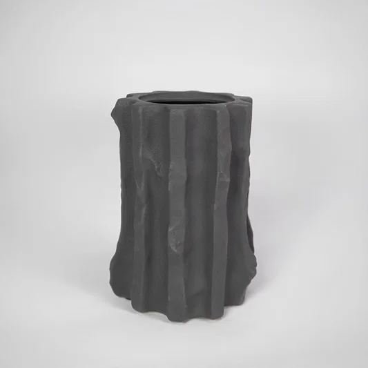 Black textured ceramic planter pot for modern indoor shelf placement and elegant home decor styling accent piece.