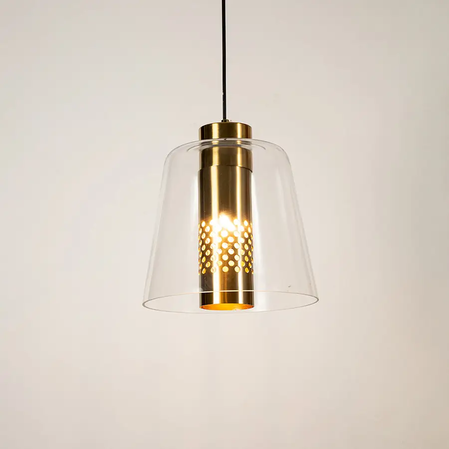 Clear glass pendant light with gold metal finish illuminated beautifully for elegant ceiling lighting decor.