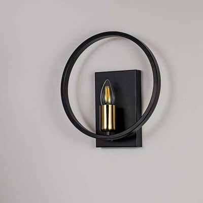 Modern wall light with matte black circular frame and gold bulb holder shown off on white background for stylish interiors.