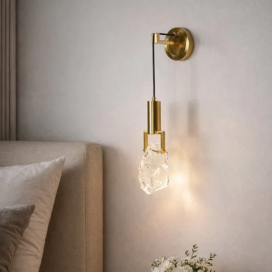 Gold metal wall light with crystal glass shade for elegant modern bedroom lighting and decor styling ideas.