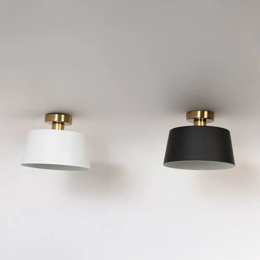 Black and white ceiling lights with gold fittings and drum shades in off mode on white background for modern ceiling decor.
