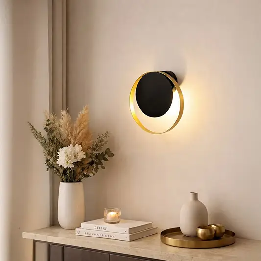 Elegant brass wall light creating warm ambient lighting in modern bedroom and vanity decor.