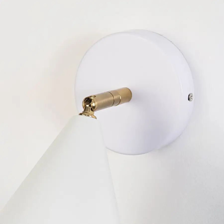 Closeup view of white metal wall sconce highlighting its conical shade smooth matte finish and warm lighting design suited for modern interior decor.