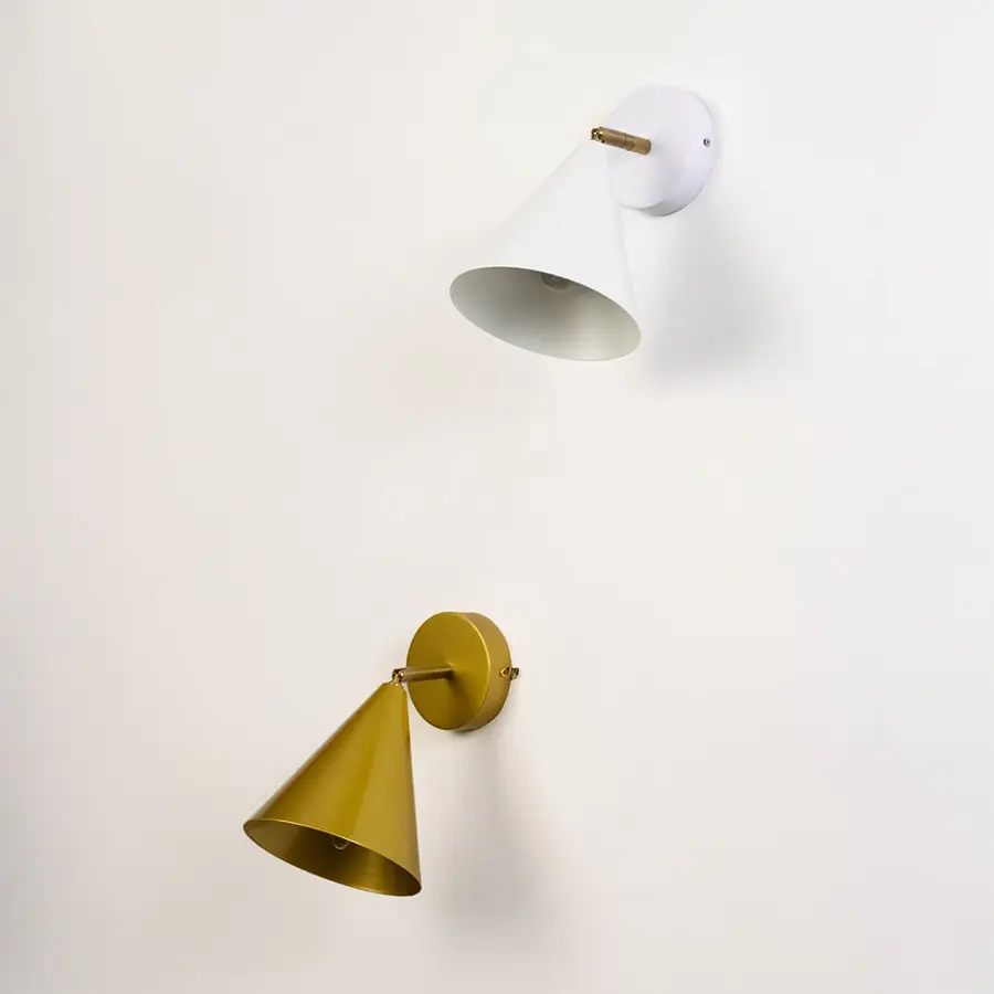White and gold cone wall sconces displayed switched off against a clean light background highlighting their sleek modern shape for interior home decor.