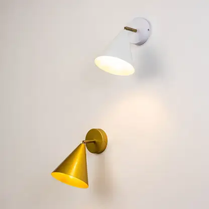 White and gold conical wall sconces glowing warmly together on a light background creating a stylish modern accent lighting look for interior home decor.
