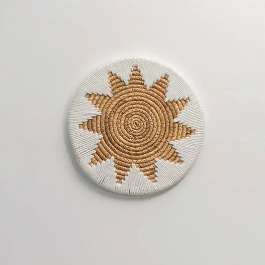 Round handcrafted natural seagrass wall basket with sunburst pattern on white background image.