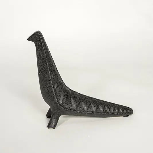 Modern dark grey ceramic decorative animal figurine with elongated body isolated on white background.