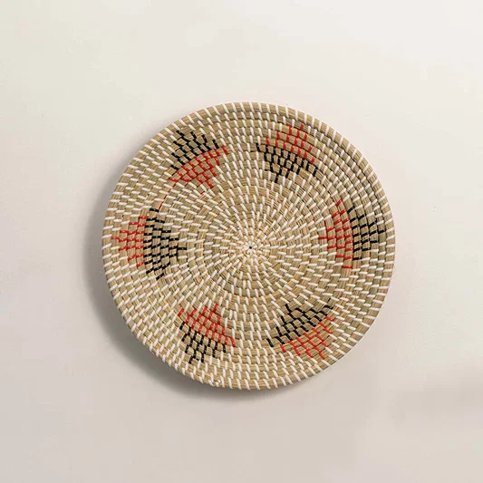 Natural woven decorative wall basket with red floral accents for artistic wall styling and modern home decor.