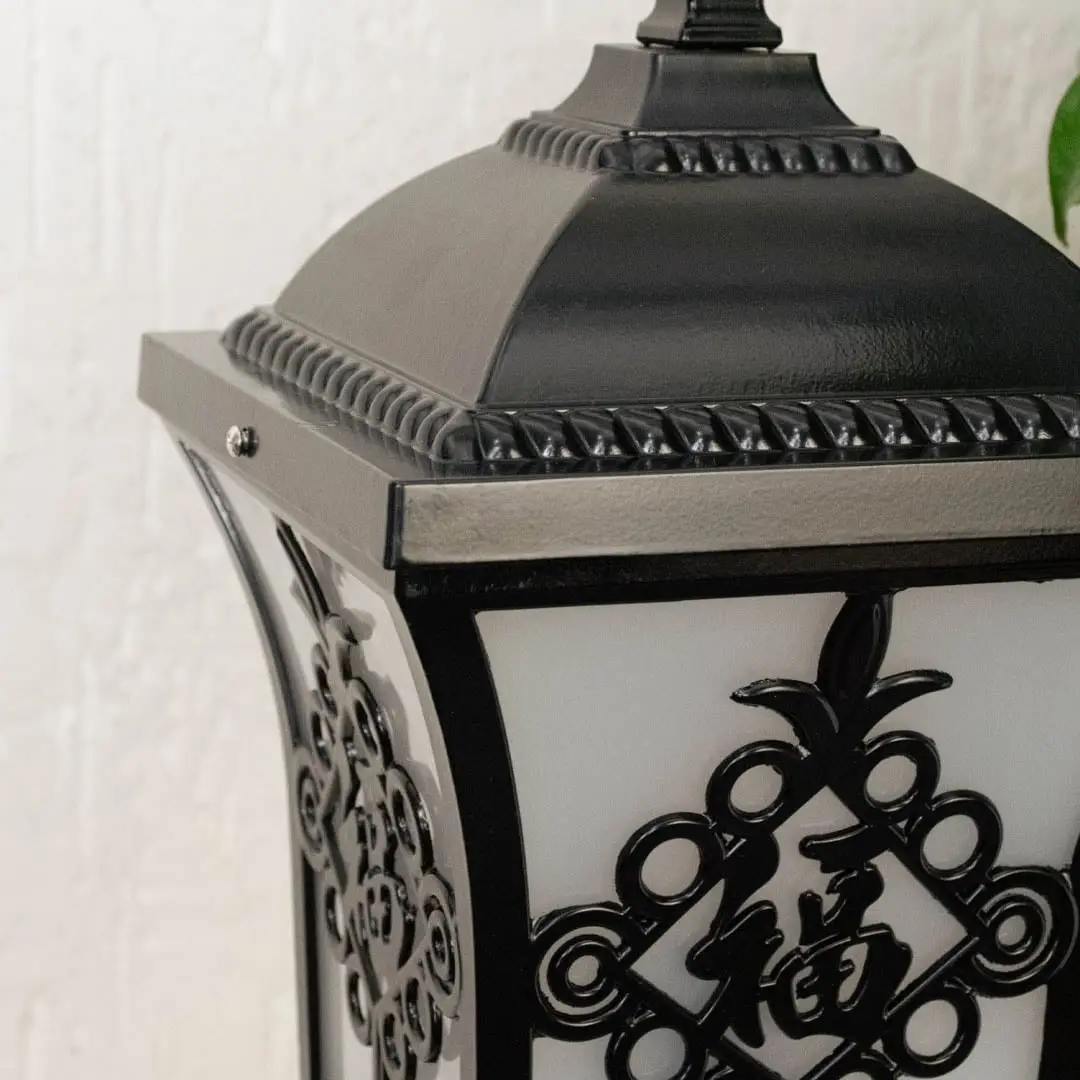 Black outdoor lantern Closeup seeded glass Light On showing the warm ambient glow and decorative pebbled glass panels detail.