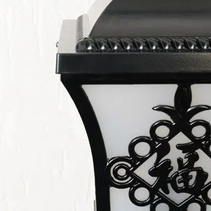 Black outdoor post light seeded glass Closeup Light On showing the textured glass and black metal base detailing on a column.