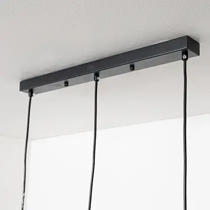 Black metal linear ceiling canopy with hanging cords highlighting premium finish and craftsmanship.