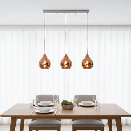 Amber glass pendant lights creating warm ambience above the dining table in modern interiors.