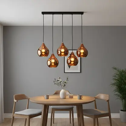 Amber metallic glass pendant lights adding warm elegance above the dining table in modern interiors.