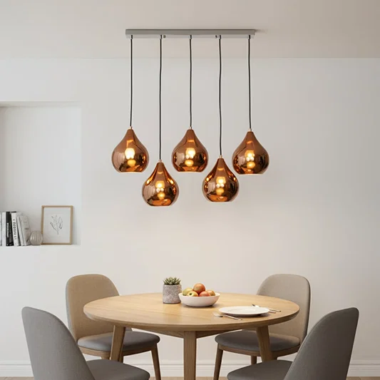 Amber metallic glass pendant lights creating cozy ambience above the dining table in elegant interiors.