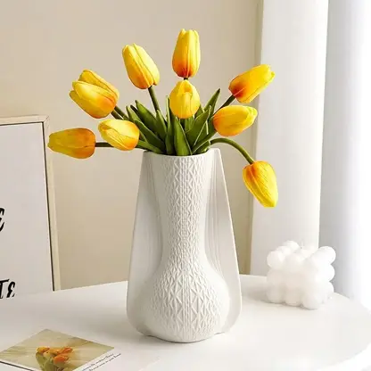 White ceramic decorative vase styled with yellow tulips creating an elegant focal point in modern home decor.