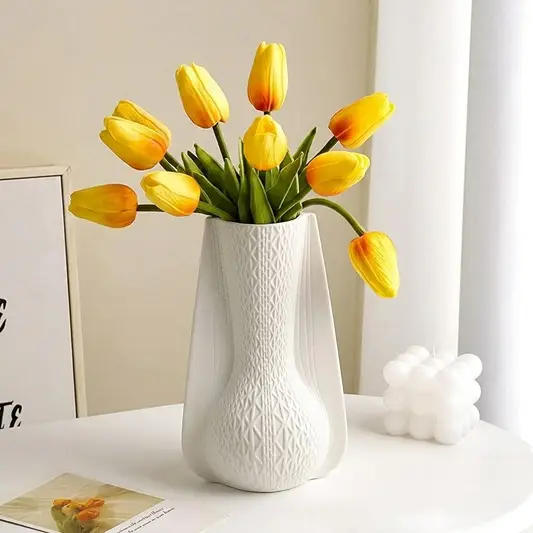 White ceramic decorative vase styled with yellow tulips creating an elegant focal point in modern home decor.