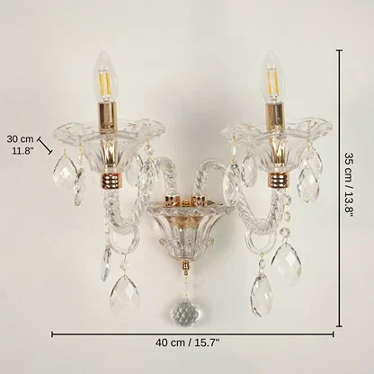 Two-light wall sconce with clear glass crystal prisms and gold-finished metal accents, 35 x 40 x 30 cm (13.8 x 15.7 x 11.8 inches) dimensions