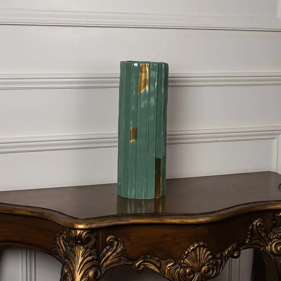 Tall green ribbed ceramic vase with subtle gold detailing shown on a plain white background perfect for minimal elegant interior styling.