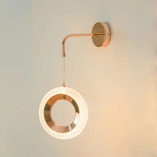 Premium rose gold led ring wall sconce lighting fixture glowing on wall for contemporary living room home decor styling.