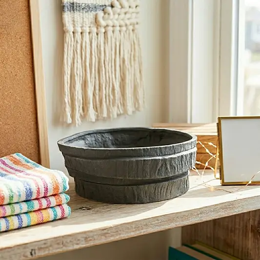 Black ceramic decorative serving bowl with textured stone finish perfect for dining table centerpiece kitchen counter styling and modern home decor.