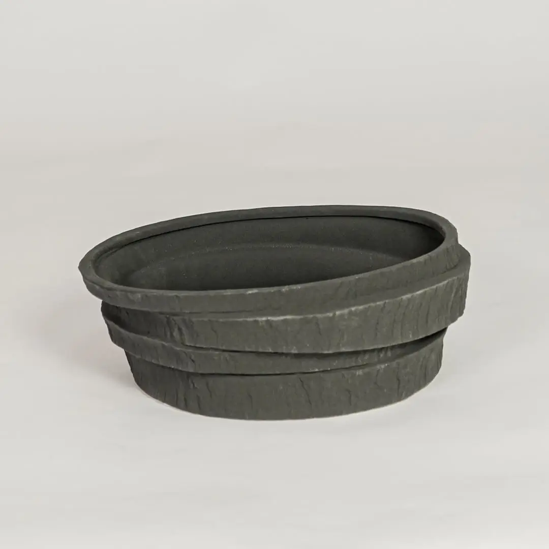 Modern black ceramic decorative bowl with textured stone design ideal for fruit display dining table centerpiece and kitchen decor styling.