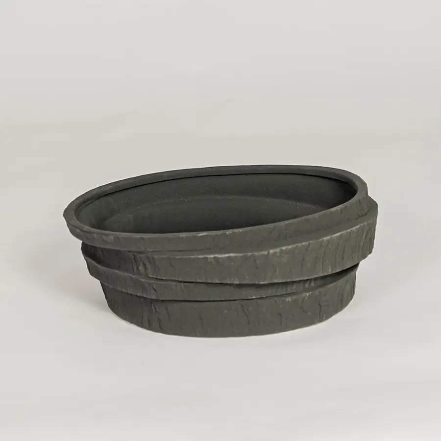 Modern black ceramic decorative bowl with textured stone design ideal for fruit display dining table centerpiece and kitchen decor styling.