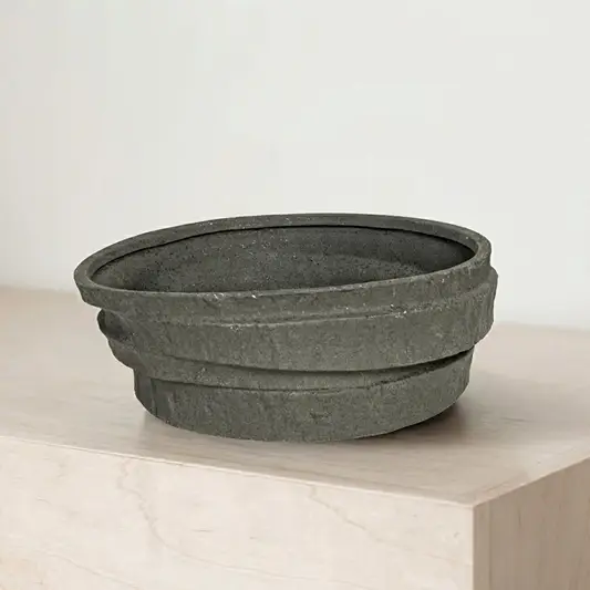 Black ceramic decorative serving bowl with textured stone finish perfect for fruit display on dining table centerpiece and modern home decor.