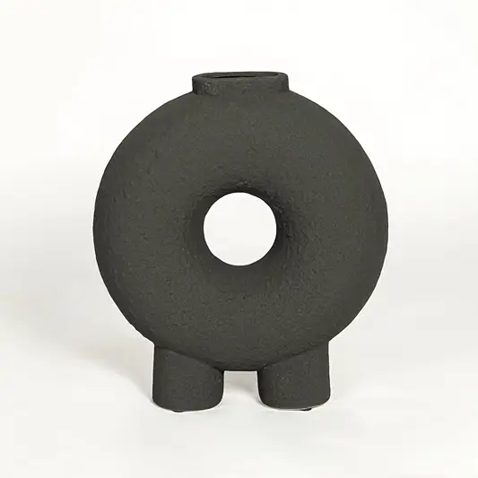 Modern black ceramic statement donut vase with hollow center for coffee table console or shelf styling.