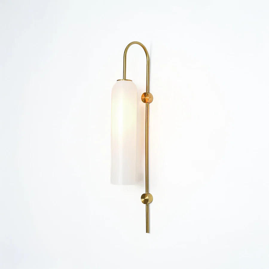 Modern gold metal wall light with white frosted glass shade for stylish bedroom and luxury decor spaces.

