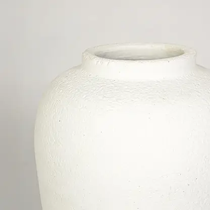 Closeup image of white ceramic decorative vase for elegant tabletop decor styling with rustic matte finish.