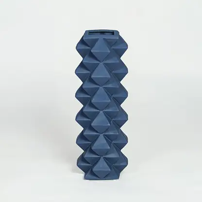 Blue ceramic geometric floor vase with faceted diamond texture isolated on clean white background for modern home decor styling.