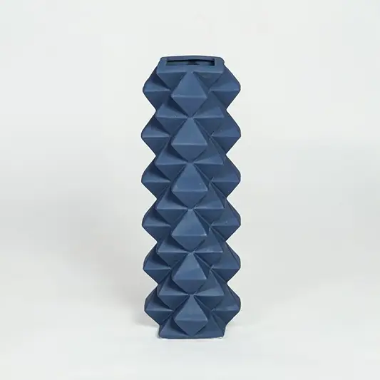 Blue ceramic geometric floor vase with faceted diamond texture isolated on clean white background for modern home decor styling.