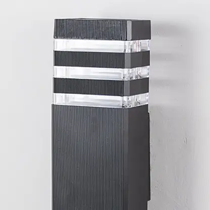 Closeup of tall black wall light showing precise detailing and clear acrylic light diffusers.