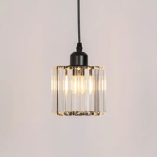 Clear ribbed glass pendant light with warm glow and black frame adding elegant ambient lighting for interiors.