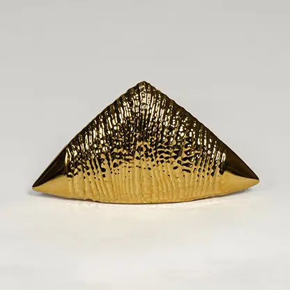 Gold striped ceramic triangle table accent isolated on clean white background for statement decor styling.