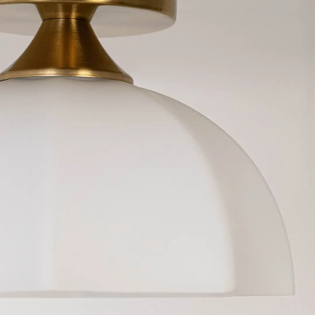 Closeup of white glass shade and gold metal ceiling light for elegant interior decor and premium styling spaces.