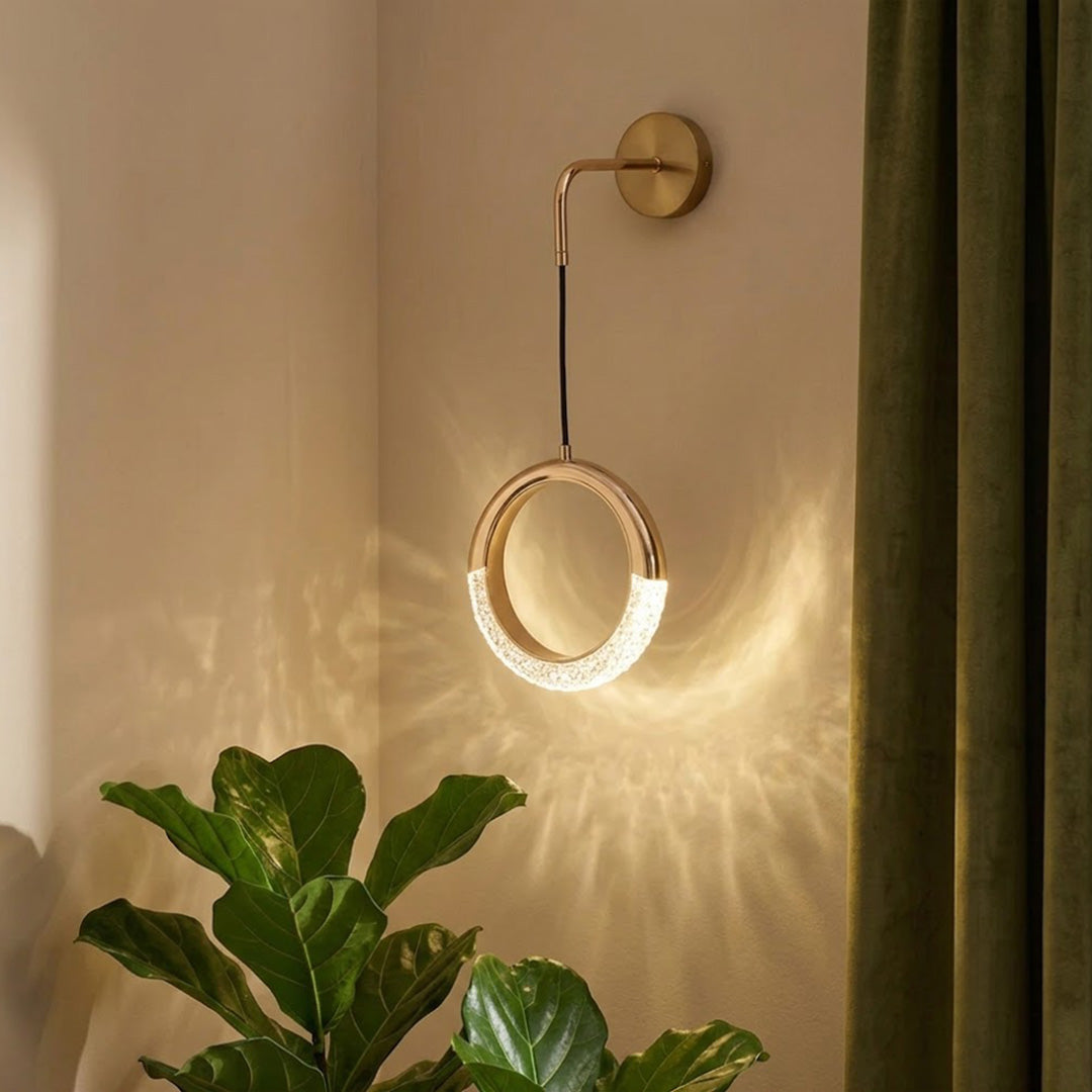 Half-moon crystal rod wall light beside framed art