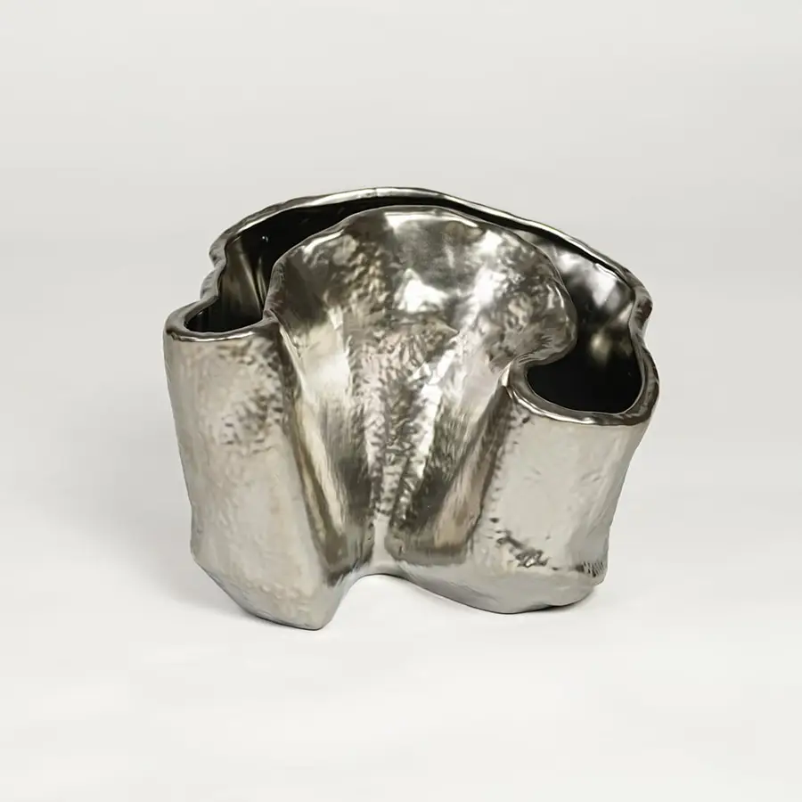 Silver metal decorative vase with sculpted organic design isolated on clean white background for luxury interior decor accent.