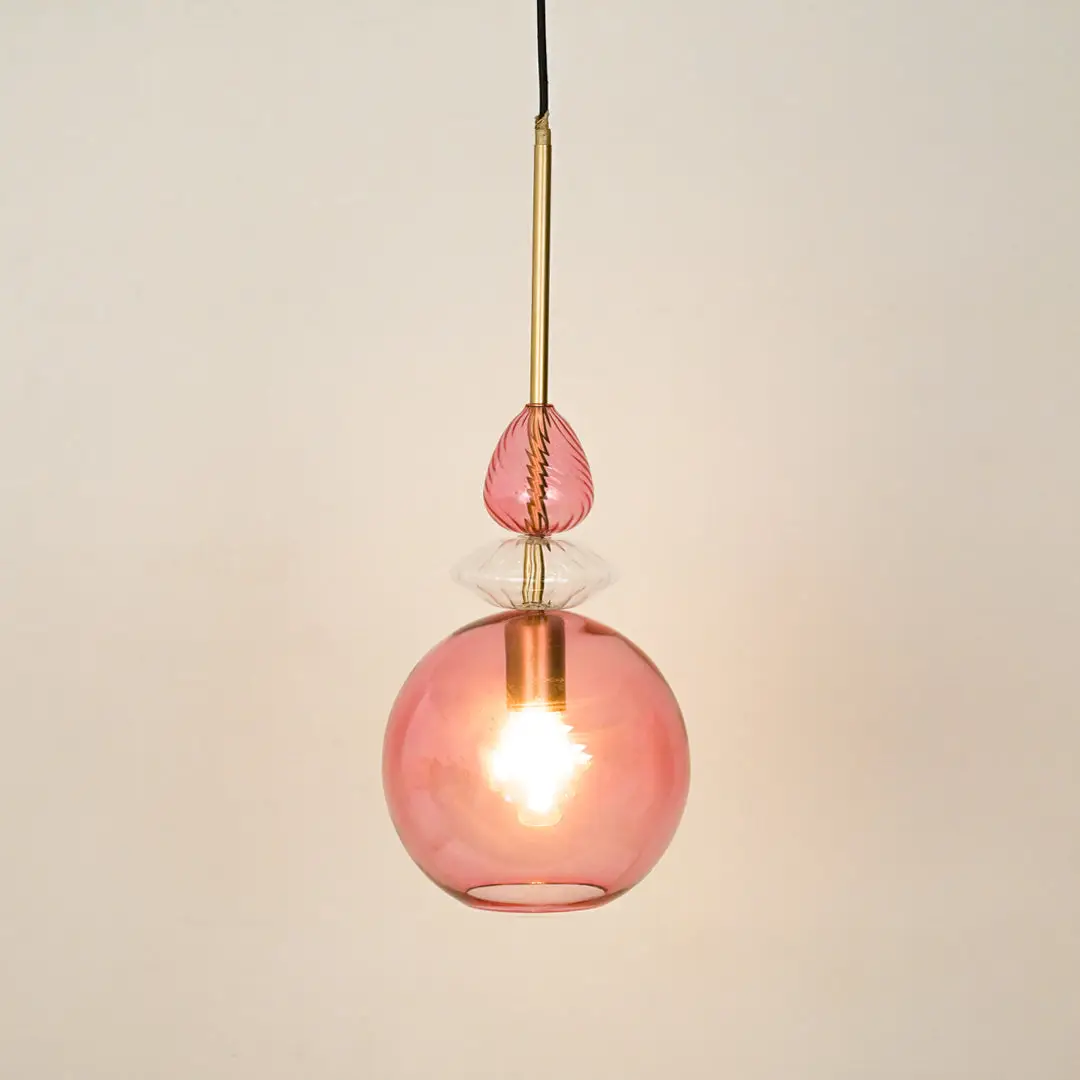 Pink glass pendant light with brass metal fitting for dining room bedroom on white background image.