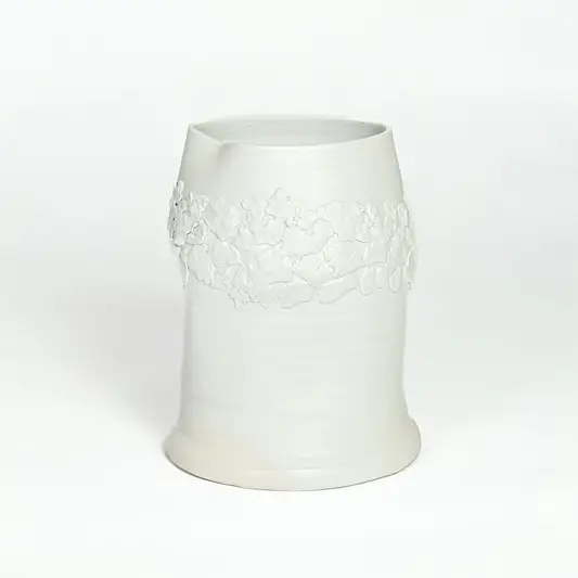 White ceramic decorative vase with embossed floral band isolated on white background for elegant tabletop decor placement.