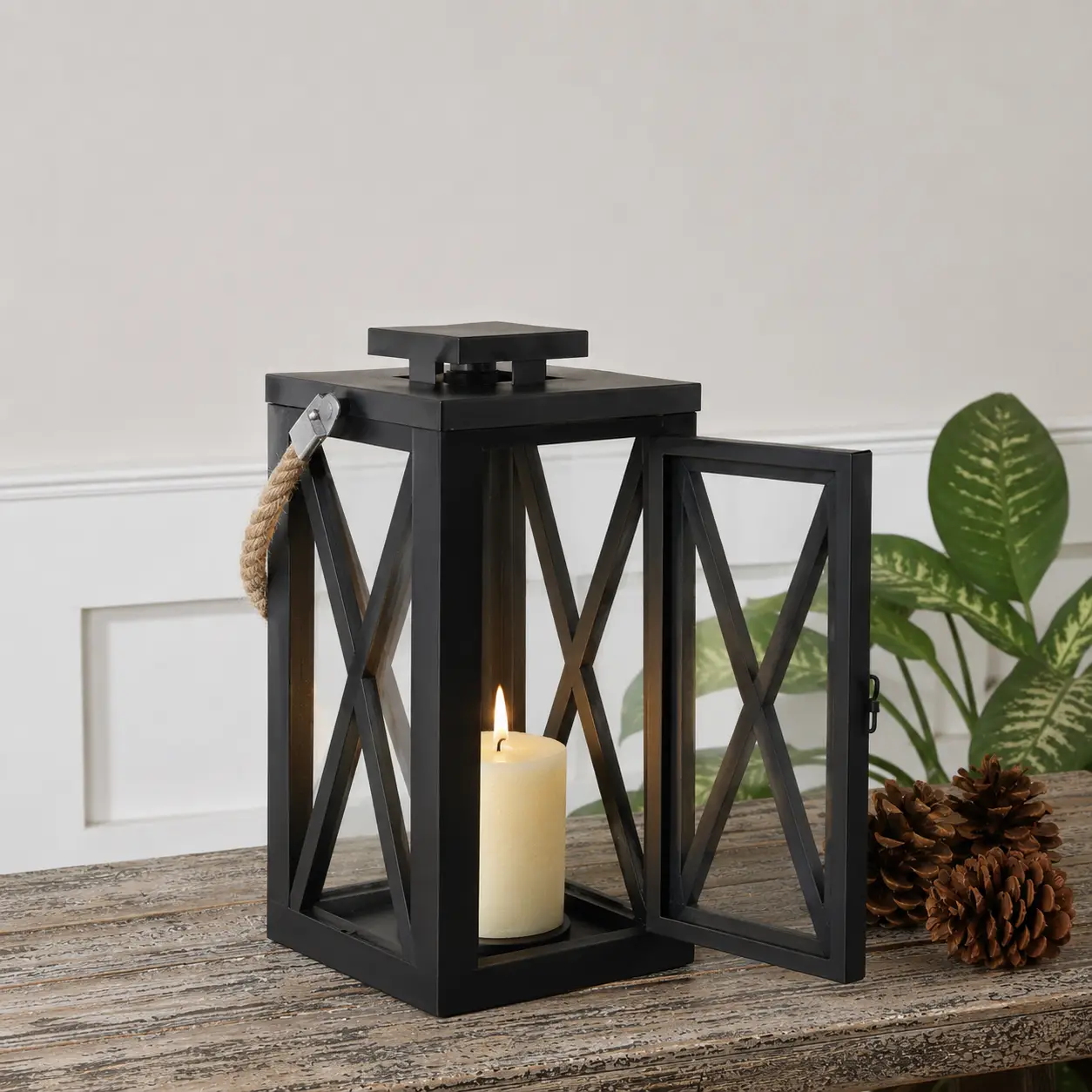 Modern black metal candle lantern with cross frame design adding decorative ambient lighting to outdoor living spaces.