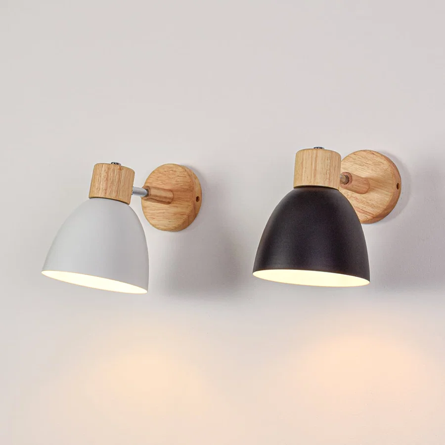 Grouped wall lights with black and white metal shades switched on creating balanced warm lighting for contemporary interior walls.