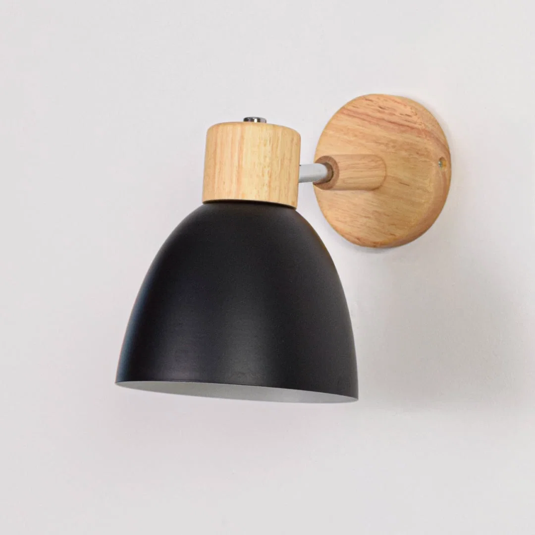 Unlit matte black metal wall sconce with natural wood details isolated on a clean white background showcasing its simple bell shape design.
