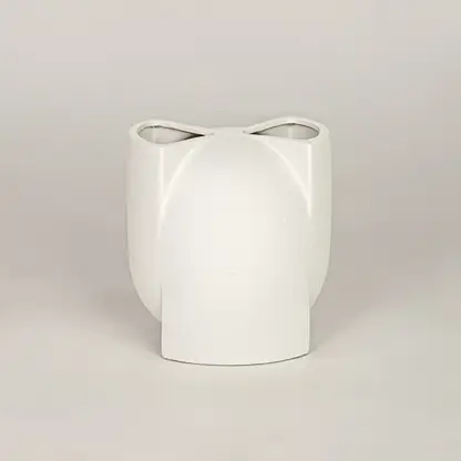 White ceramic decorative vase with sculpted modern design for tabletop shelf and console decor placement.