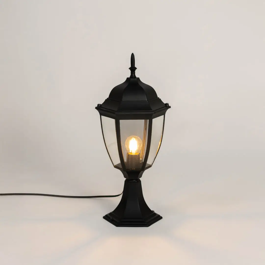 Classic black outdoor gate light with warm glowing bulb for stylish exterior decor styling use.