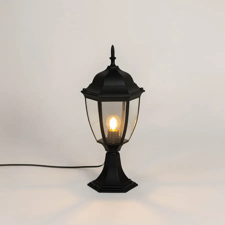 Classic black outdoor gate light with warm glowing bulb for stylish exterior decor styling use.